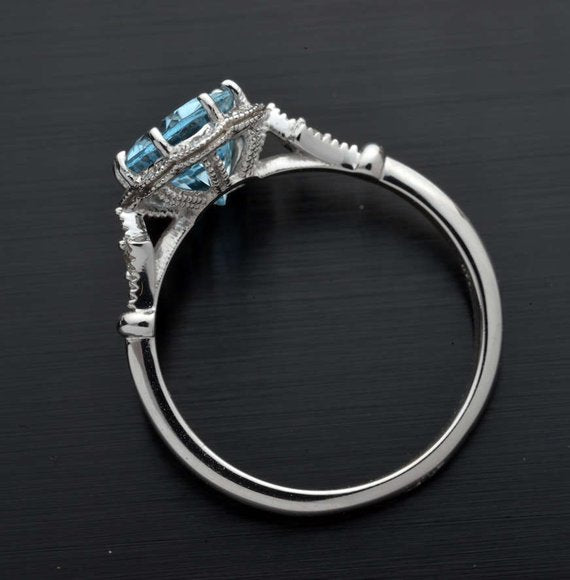 side view of an oval engagement ring with an aqua marine stone