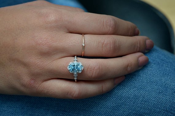 hand with white gold ring blue stone