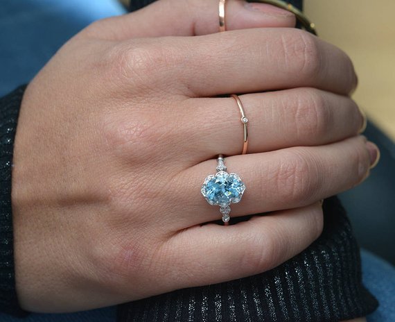 hand with white gold ring blue stone