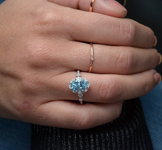 hand with white gold ring blue stone