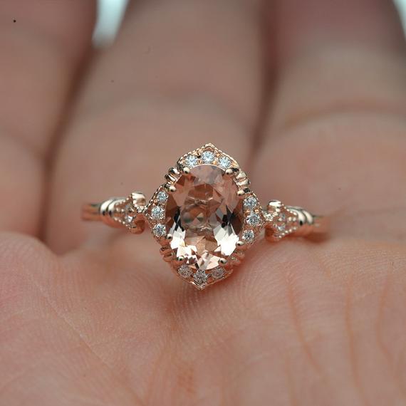 oval halo engagement ring vintage inspired with a morganite in rose gold in a hand