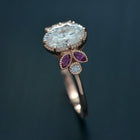 Oval engagement ring with marquise rubies in rose gold side view